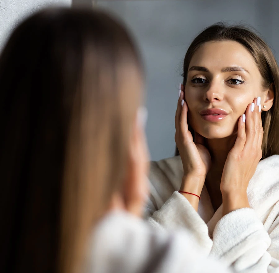 woman looking at herself in a mirror | Raj Dedhia MD San Francisco, CA