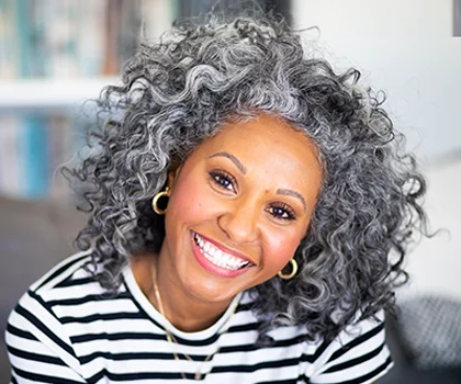 smiling black woman in her livingroom - Facelift Procedure in San Francisco, CA